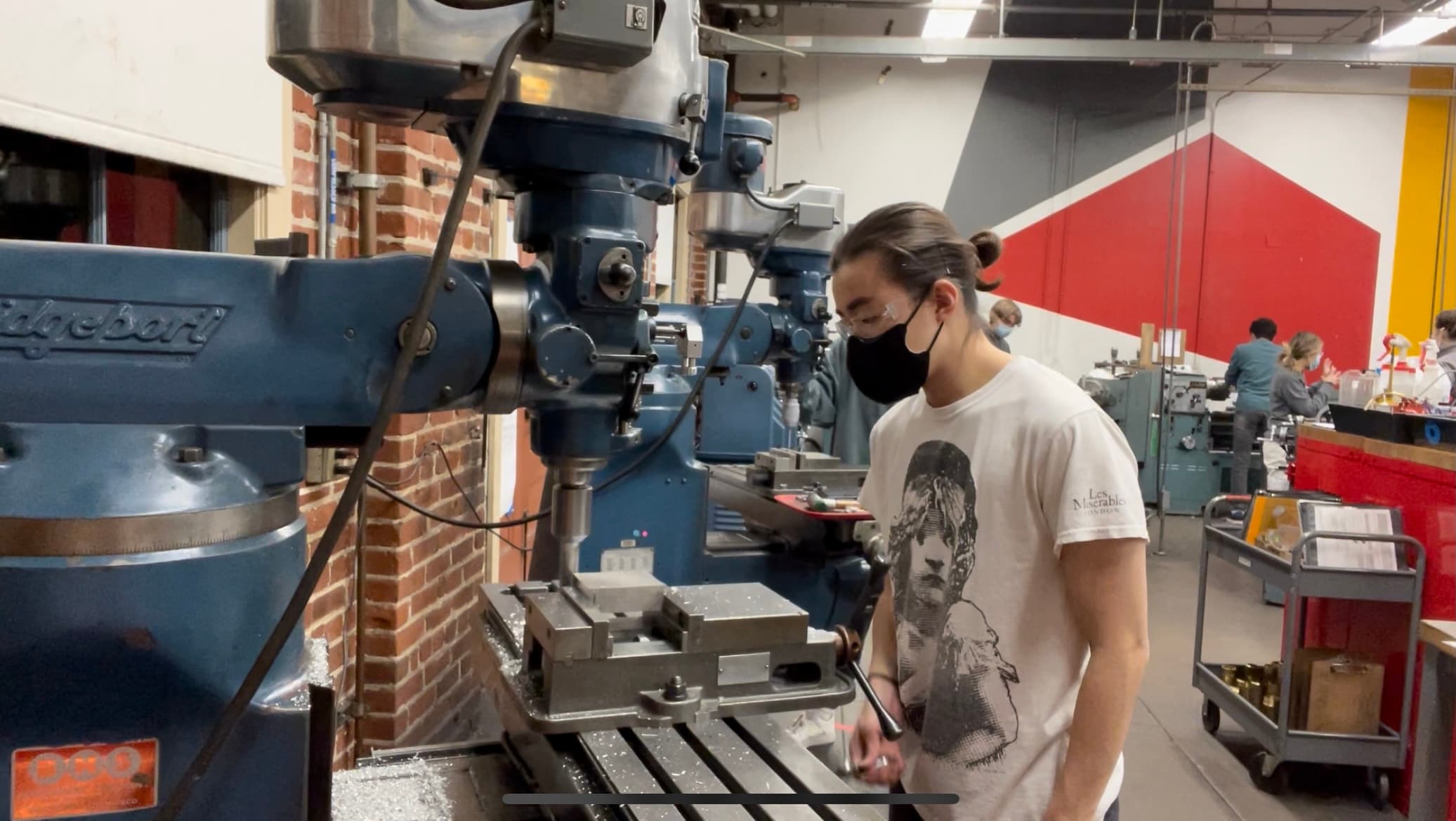 A student operating a milling machine